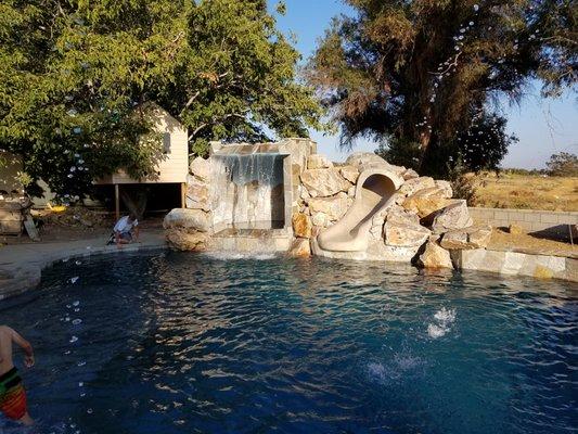 Waterfall spa grotto with custom slide in Cherry Valley. ~American Heritage Pool Corporation