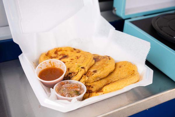 The pupusas served with curtido and salsa roja.