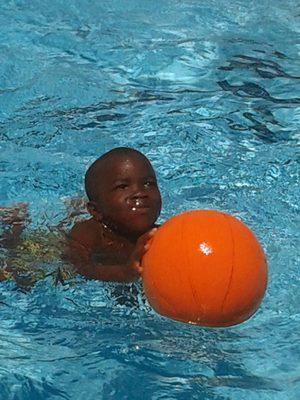 Elijah shooting hoops in the pool.