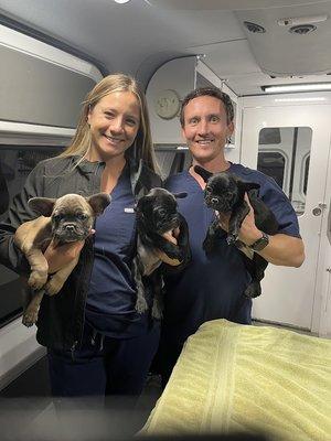 Dr. Lefmann and nurse holding puppies in mobile vet truck.