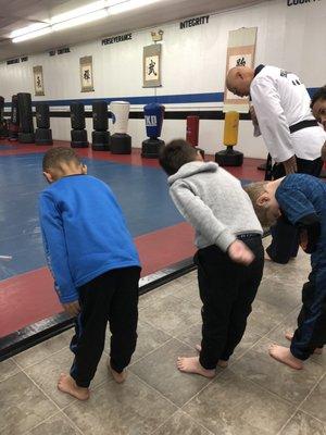 The procedure is to place a closed right fist over your heart and bow to the flag before stepping onto the mat.