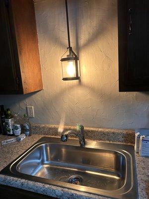 Kitchen sink, faucet, and light fixture.