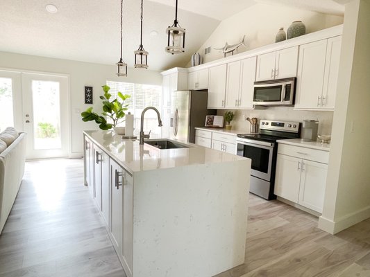 Waterfall quartz countertops on island, and quartz backsplash