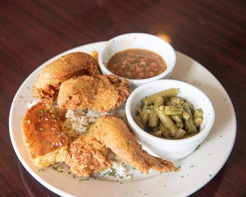 Fried chicken wing plate with green beans, baked beans and sweet cornbread