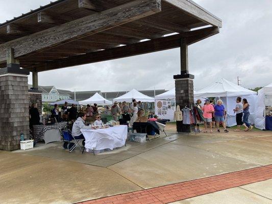 Farmers' Market booths under the pavilion and bordering the grassy common.