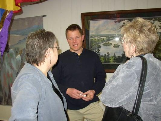 Artist Paul Oman, talking with customers who attended his art show, March 2009