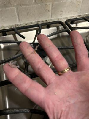 More dust on kitchen countertops at edge of stovetop.