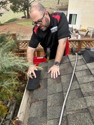 Clearing gutters and putting in a downspout blocker