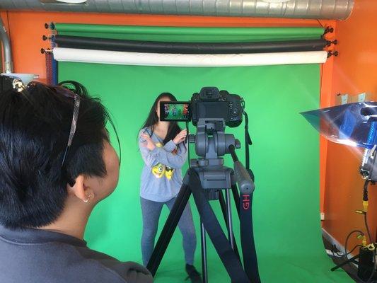 students shooting video with green screen