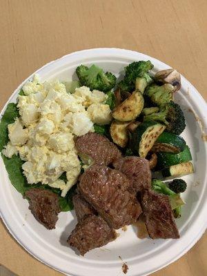 $7.99 steak with potatoes salad and zucchini broccoli mushrooms