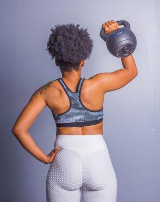 women working kettle bell working shoulders from the rear