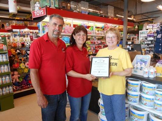 Diane from Forever Paws Animal Shelter presenting a certificate of appreciation to Steven and Mellisa