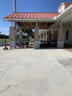 Covered area with picnic tables, bathrooms and water.