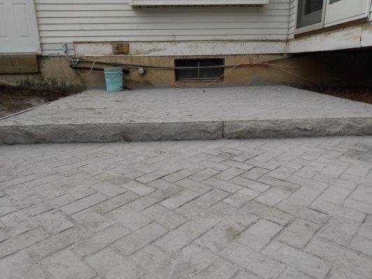 Herringbone brick stampede concrete patio, with step