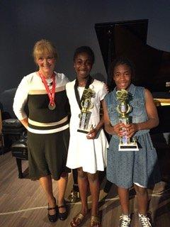 Students receive trophies for memory pages, Patti is wearing her triathlon trophy for participation same day as recital.