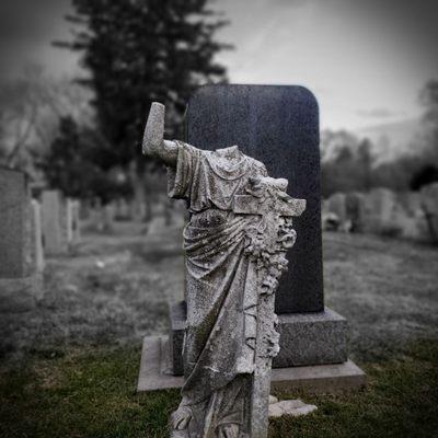 An antique, headless statue among the stones