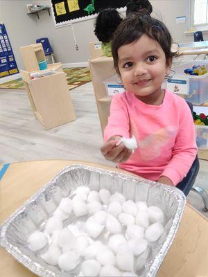 Playing in her Bunny Sensory Bin filled with Cotton Balls and Bunnies