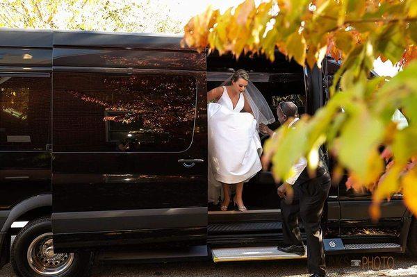 A bride exits our Mercedes Sprinter limo bus on her wedding day.