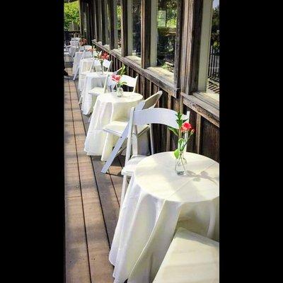 Bistro Tables and White Folding Chairs Made A Lovely Seating Arrangement For This Narrow Porch. We Deliver!