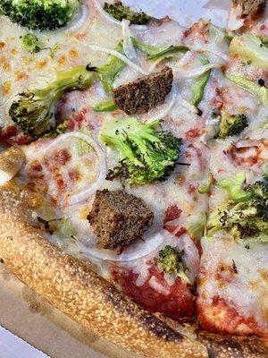 Pizza with meatball, onion, pepper, and broccoli.