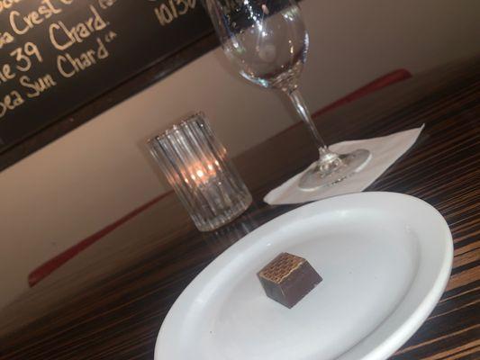 A delicious chocolate truffle and a delicious tintero Moscato.