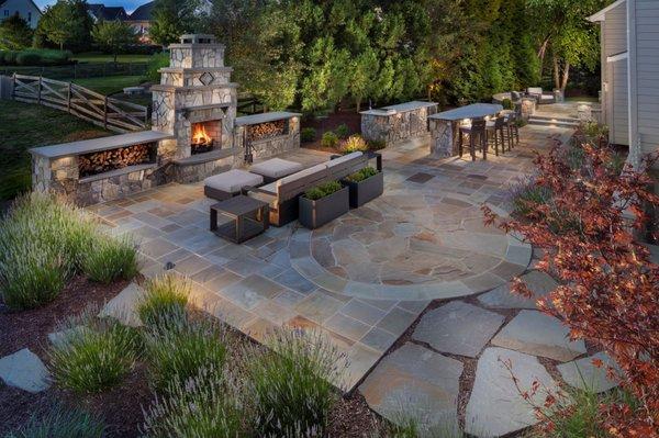 Flagstone patio, outdoor kitchen, wood burning fireplace, LED lighting and planting.