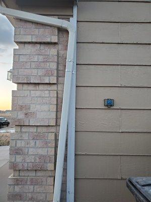 Downspout installed incorrectly. Not enough supporting straps, doesn't line up with the house.