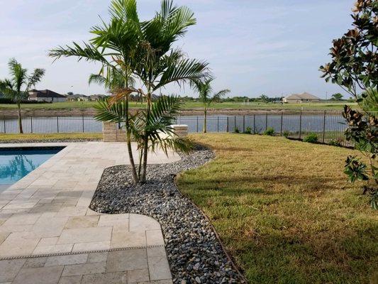 River rock accenting the decking around the pool