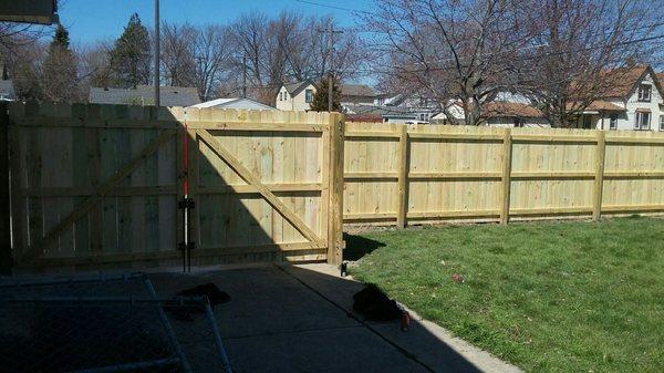 Wood privacy fence with double drive gates.