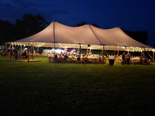 Aurora sheer sailcloth tent with cafe streamer lighting at night