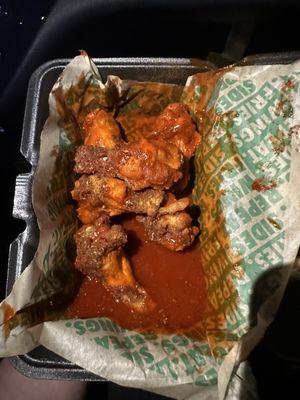 Disgusting uncooked submerged in sauce Cajun wings