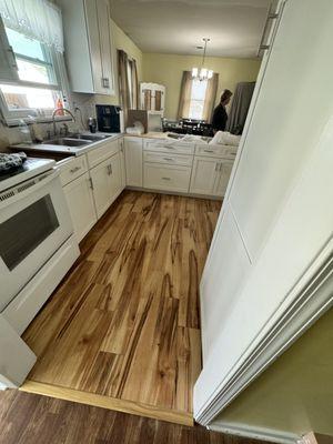 An entire kitchen remodeled new cabinets, fresh paint and laminate floor.