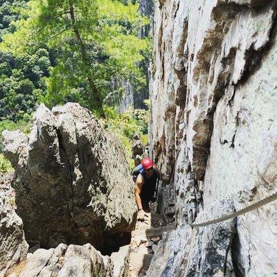 Rock scrambling moment that requires you to fit between rocks and hoist yourself up and over.