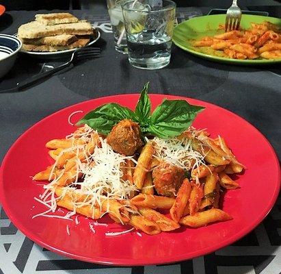 Penne pasta in tomato sauce and beef meatballs. Topped with Parmesan cheese