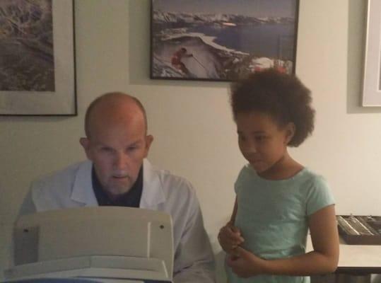 Dr. Van showing my daughter how to perform one of the vision tests.