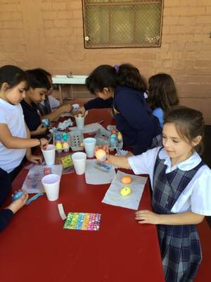 5th and 1st grade buddies painting Easter Eggs