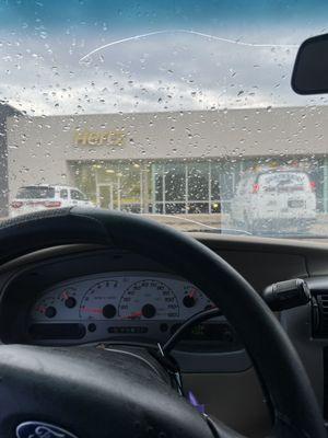 Outside of Hurtz with rain on our windshield upon returning the truck further showing that it was still raining when we got back...