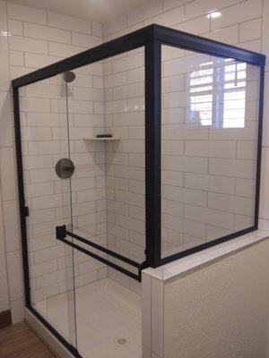 Bi-pass shower door with step return panel. Clear glass, black metal. Hilton Glass and Door 208-263-3322