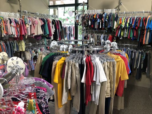 The children's clothing department is tidy and organized by size.