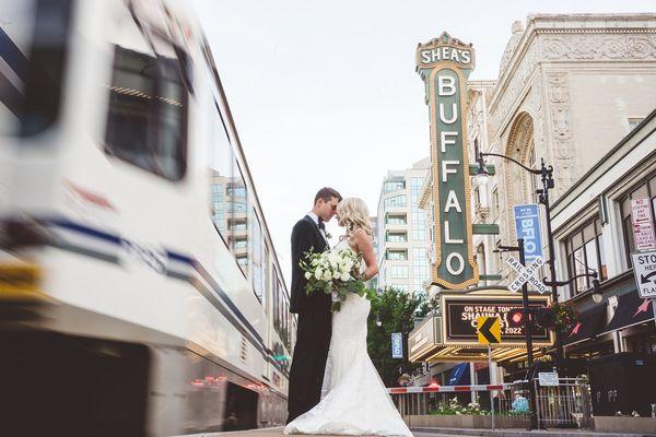 Couple next to a moving train on Main Street in Buffalo NY