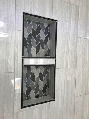 The leaf mosaic tile is carried into the niche for stronger highlight.