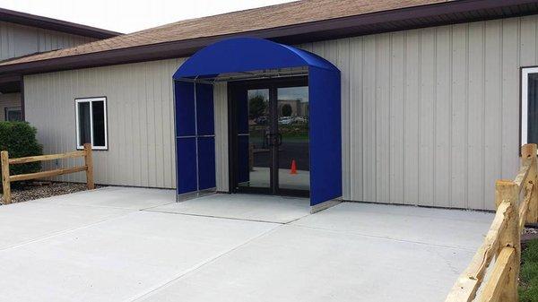 Custom canvas awning with side walls made to match make it become an enclosure.