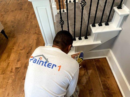 Painter doing final touchups on a stairway remodel.