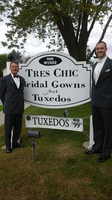 Groom and father bringing attention to Tres Chic Sign. Plus how nice they look.