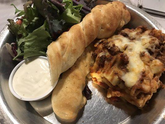 Lasagna, side salad with ranch and breadsticks.