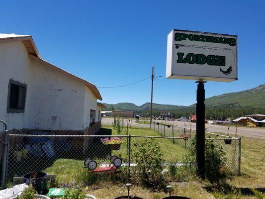 Sign above dog area and highway with elk close by