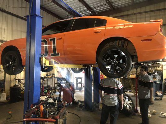 Drive shaft of a 2014 Dodge Charger R/T being removed and replaced.