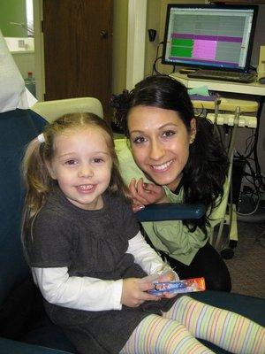 Dental Hygienist posing with a child patient.