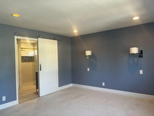 Devin painted this Master Bedroom and installed 2 scones and barn door leading to master bath;