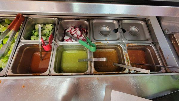 Condiment bar, sauces, radishes, cucumbers